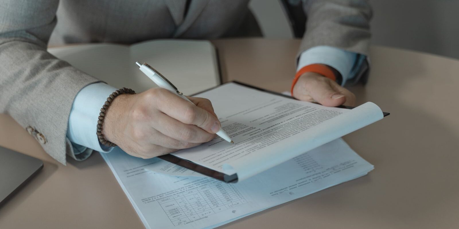 Persona revisando y firmando un contrato de trabajo en una mesa de oficina