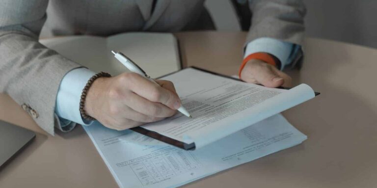 Persona revisando y firmando un contrato de trabajo en una mesa de oficina